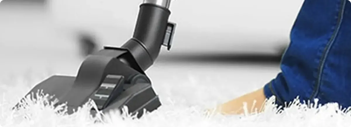 Close-up of a professional vacuuming a white carpet in Woodbridge.